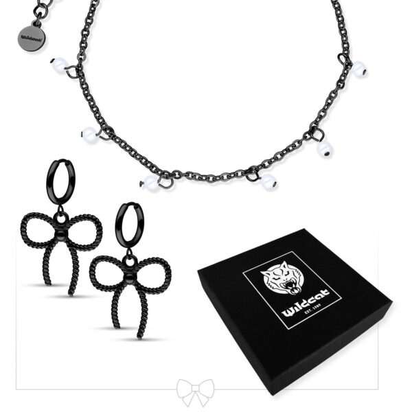 Pulsera de perlas negras con pequeñas perlas y pendientes de lazo negros sobre fondo blanco