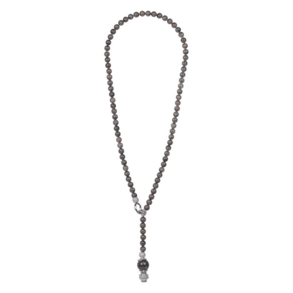 Collar largo negro con perlas redondas y colgante sobre fondo blanco