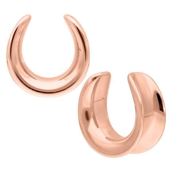 Dos Ear Saddles de oro rosa de acero quirúrgico sobre fondo blanco