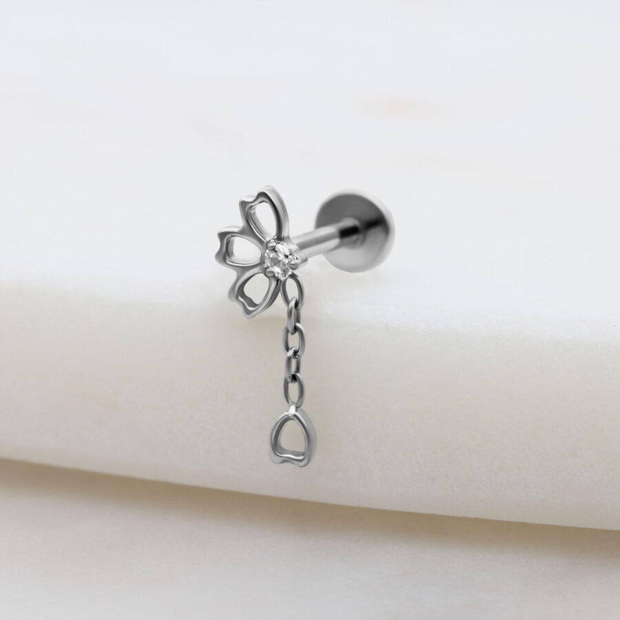 Ajuste de piercing plateado con cadena de cristal claro sobre fondo blanco
