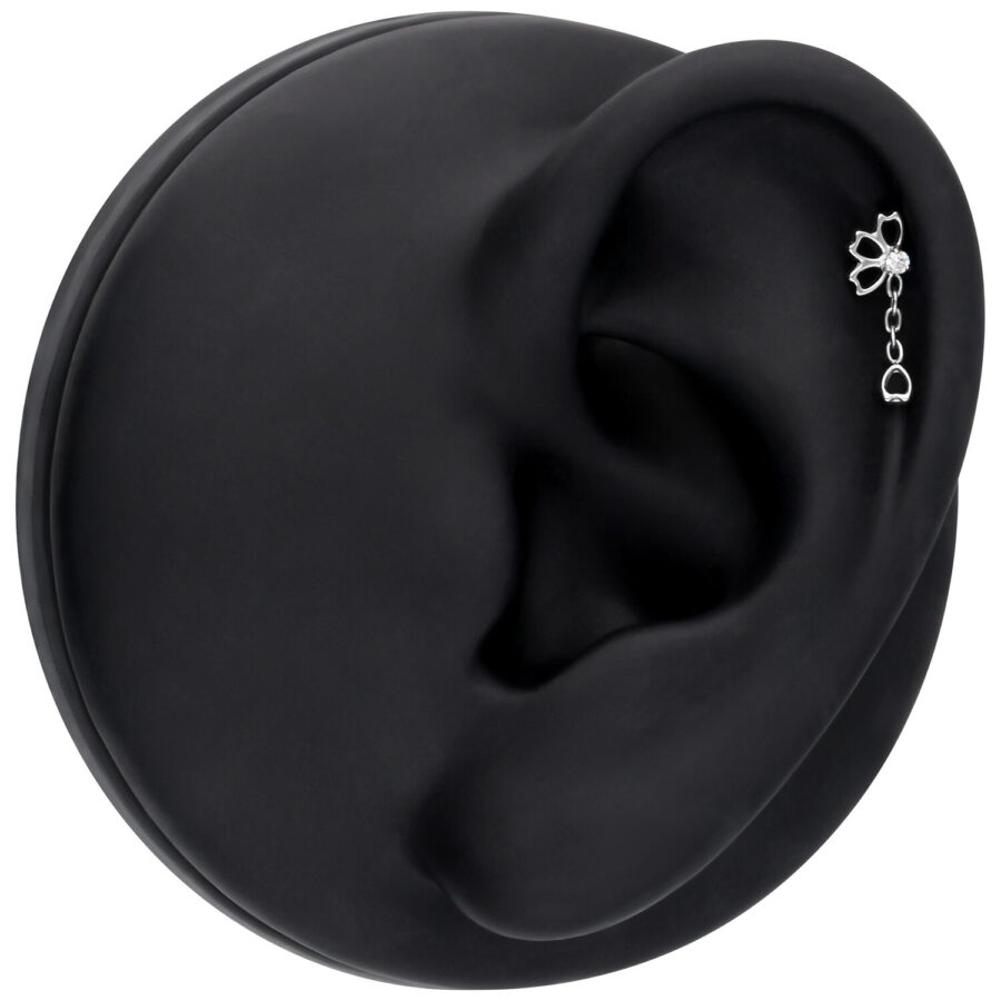 Accesorio de piercing de oreja plateado con cristal sobre fondo negro