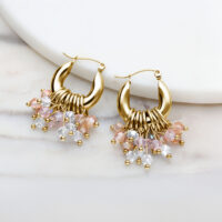 Pendientes de aro dorados con colgantes de cristal de colores sobre fondo blanco