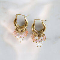 Pendientes Glamour Hoops de oro con cristales rosas y transparentes sobre fondo de mármol