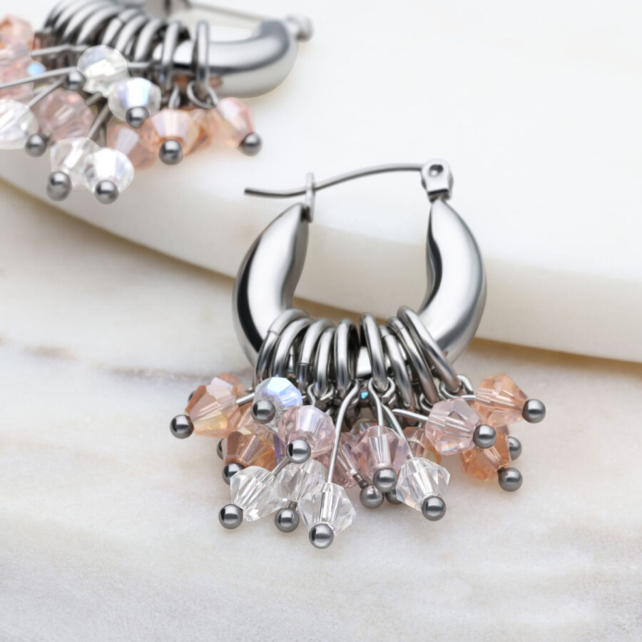Pendientes Glamour Hoops plateados con cristales de colores sobre fondo marmolado