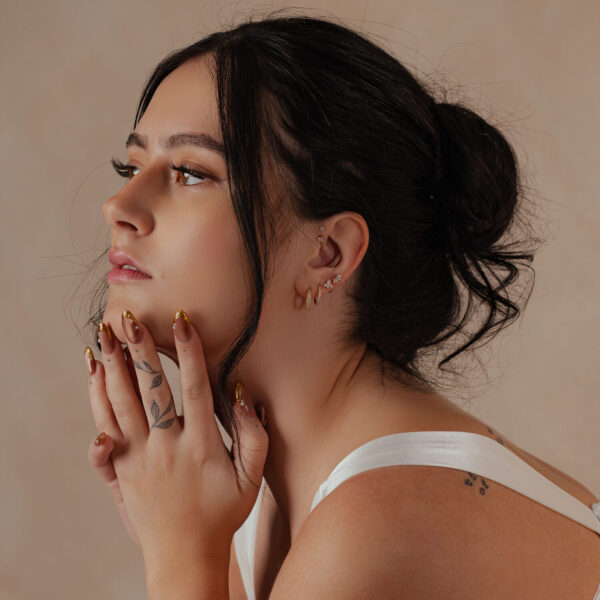 Mujer con aro de piercing en Oro 14K en la oreja, vista lateral