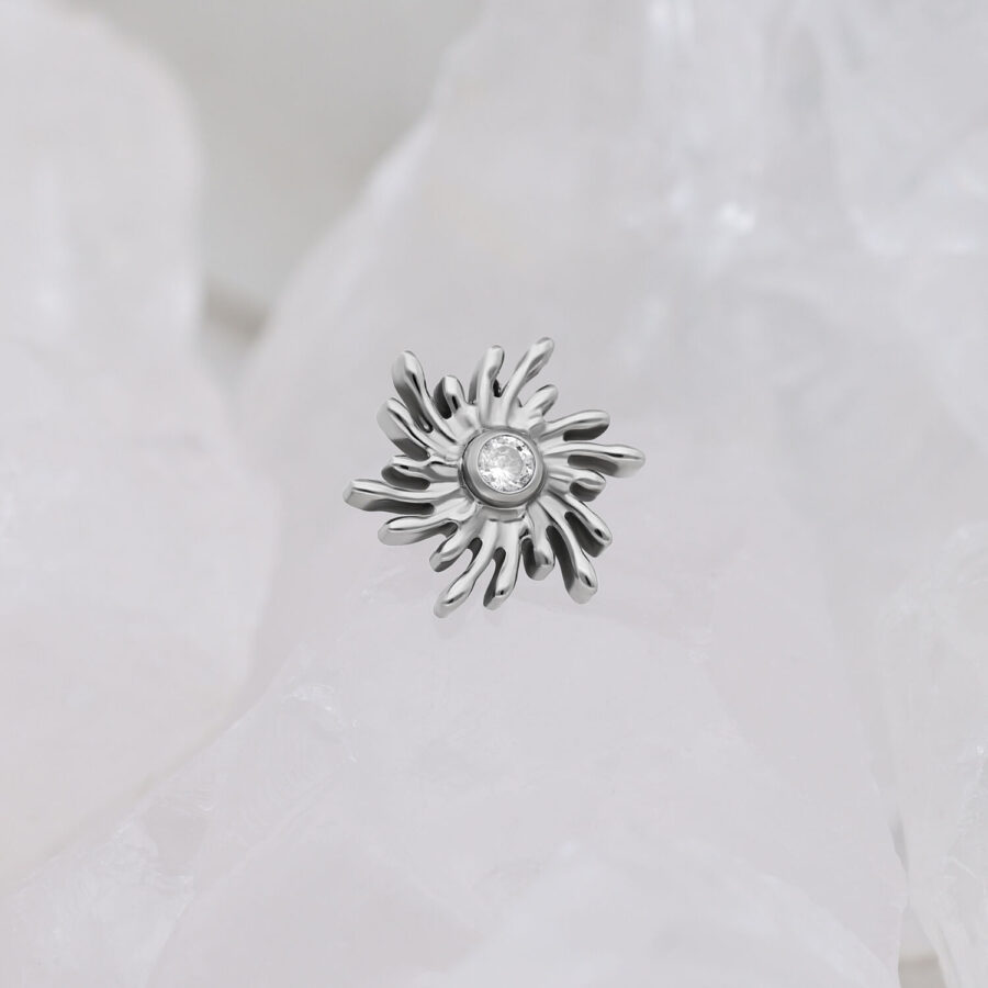 Ajuste Sunburst plateado con piedra cristalina sobre fondo blanco