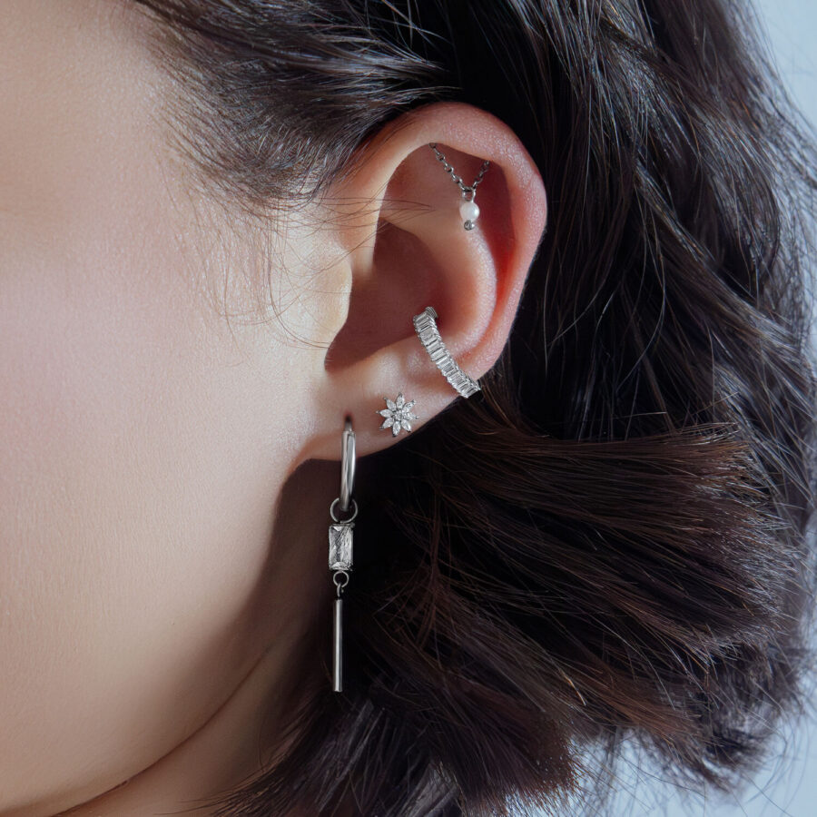 Ice Flower de Cristal Plateado en una oreja con otros piercings plateados