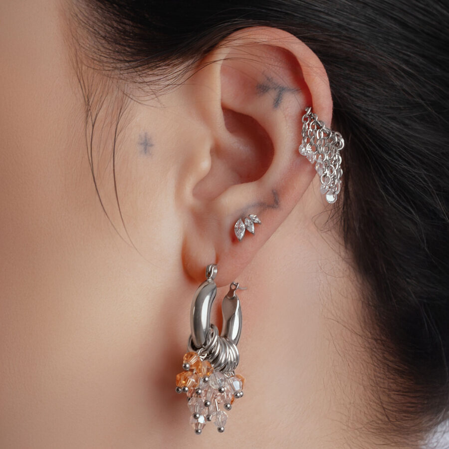 Glamour Hoops plateados y dorados en la oreja de una persona, primer plano
