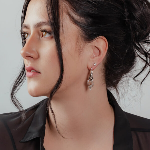 Mujer con aros glamurosos de plata y oro, look elegante
