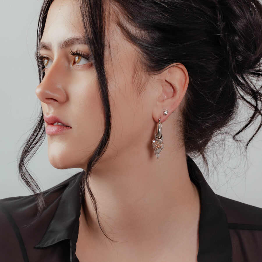 Mujer con aros glamurosos de plata y oro, look elegante