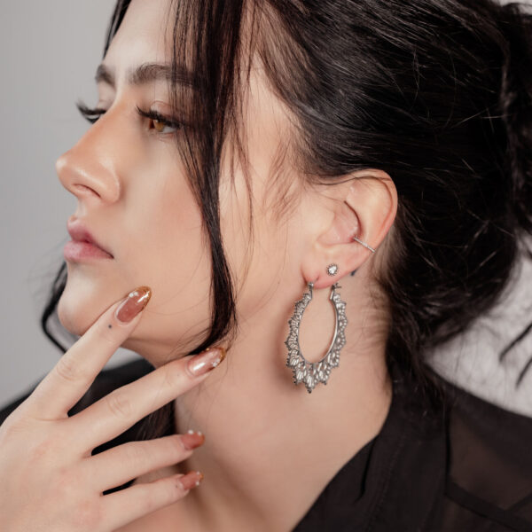 Mujer con cabello negro lleva aros Sunflower plateados