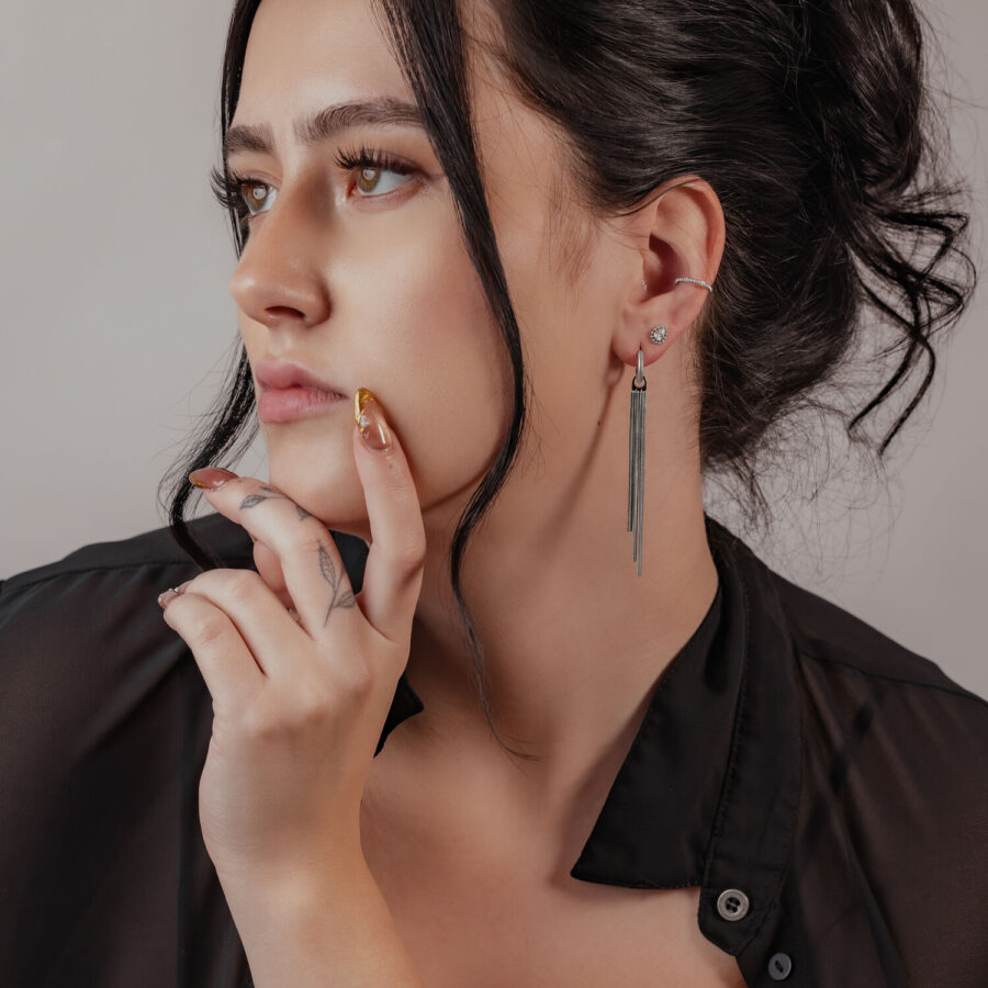 Mujer con elegante perforación Clicker de perlas en plata en la oreja, cabello negro