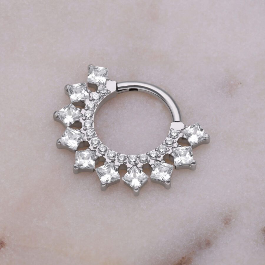 Clicker para septum plateado con cristales sobre fondo marmoleado