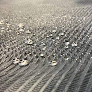 Nahaufnahme einer schwarzen, wasserdichten Abdeckrolle mit Wassertropfen