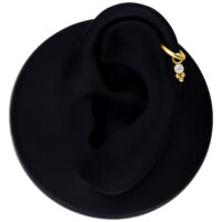 Colgante de piercing de cristal dorado en un modelo de oreja negra