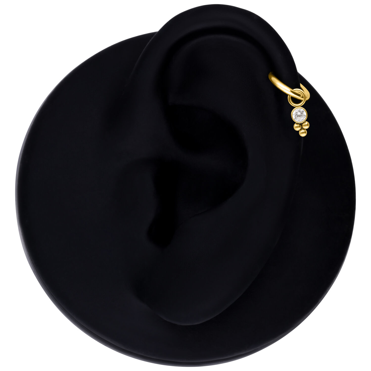 Colgante de piercing de cristal dorado en un modelo de oreja negra