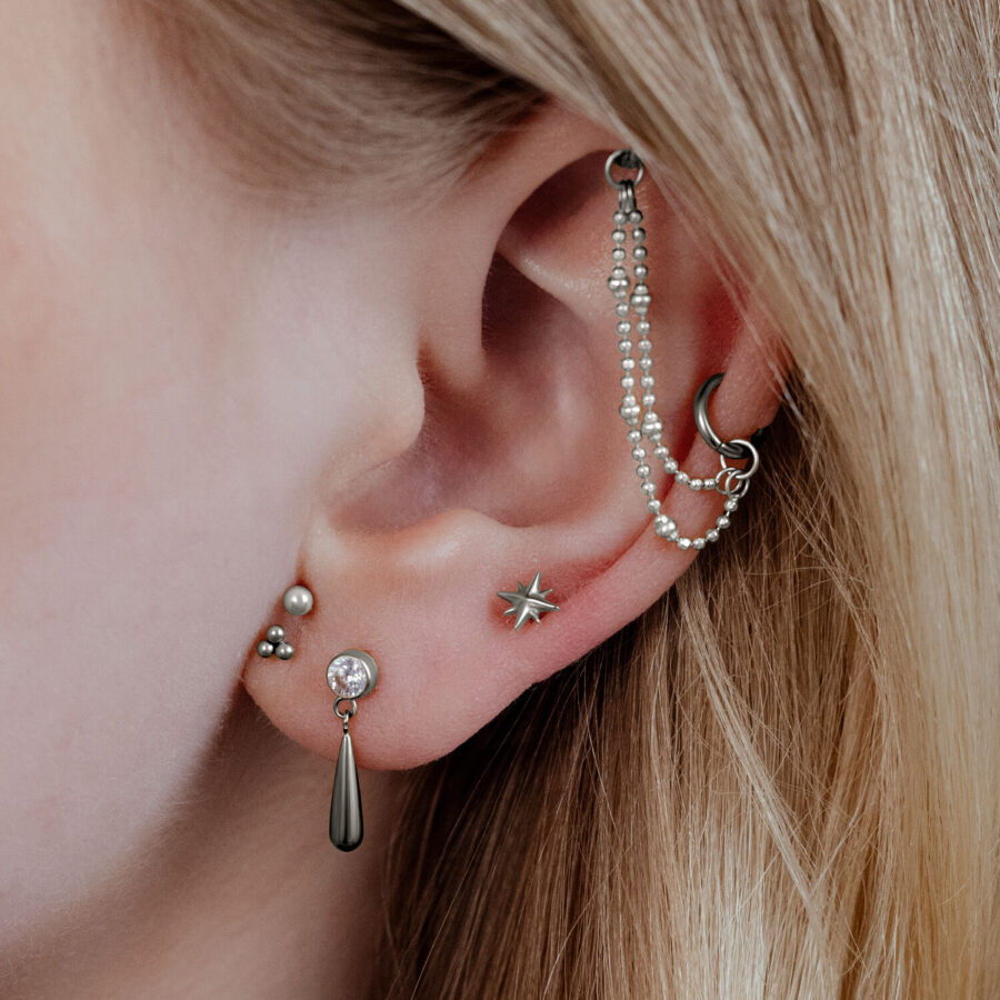 Accesorio de estrella Push Fit plateado en piercing de oreja, primer plano