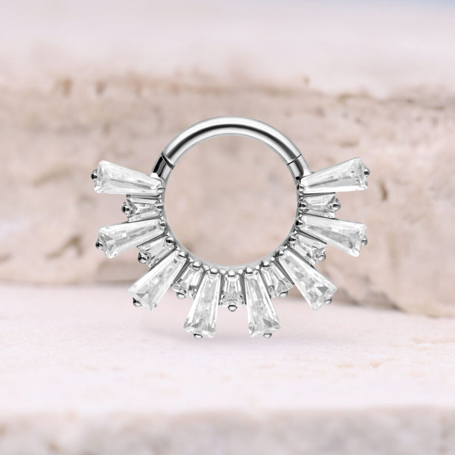 Clicker de septum plateado con cristales sobre fondo claro