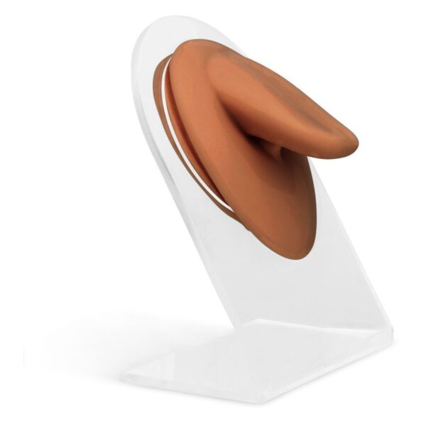 Accesorio de silicona marrón sobre soporte transparente frente a fondo blanco