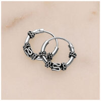 Aros de plata con detalles de nudo sobre fondo claro