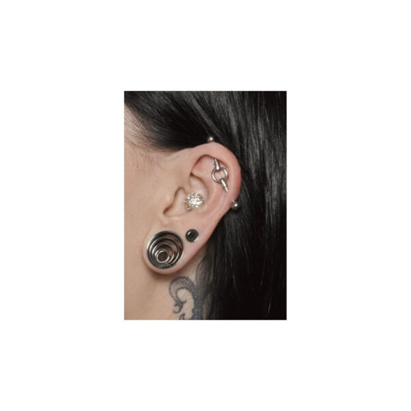 Primer plano de una oreja con Industrial Piercing plateado y otras joyas de oreja