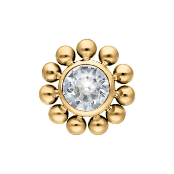 Aplique de titanio dorado con piedra cristalina y forma de flor sobre fondo blanco