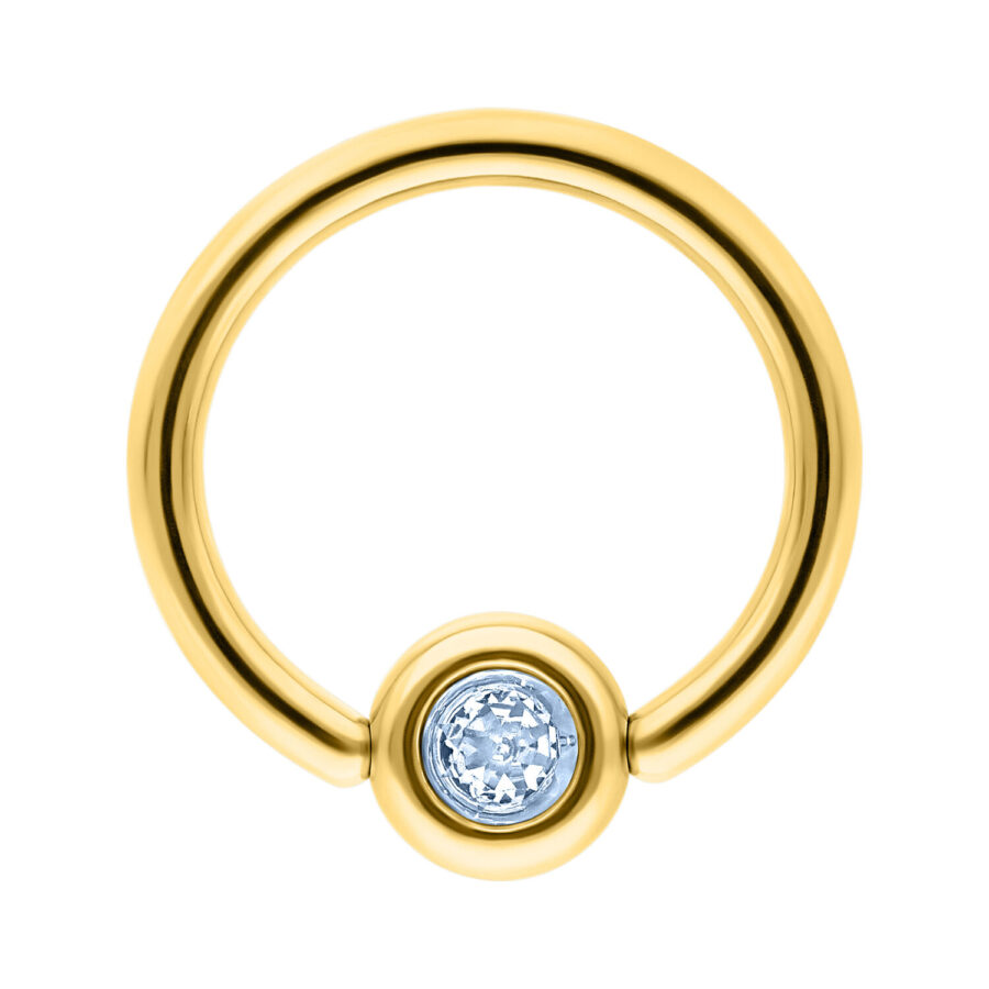 Anillo de titanio dorado con cristal azul claro sobre fondo blanco