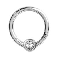 Anillo de piercing plateado con cristal claro sobre fondo blanco