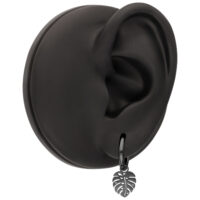 Pendientes negros con colgante de Monstera en un modelo de oreja negro