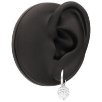 Pendientes de Monstera plateados en oreja negra Oreja de modelo negra con pendiente de Monstera plateado, fondo blanco