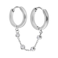 Aros plateados con cadena de cristal sobre fondo blanco