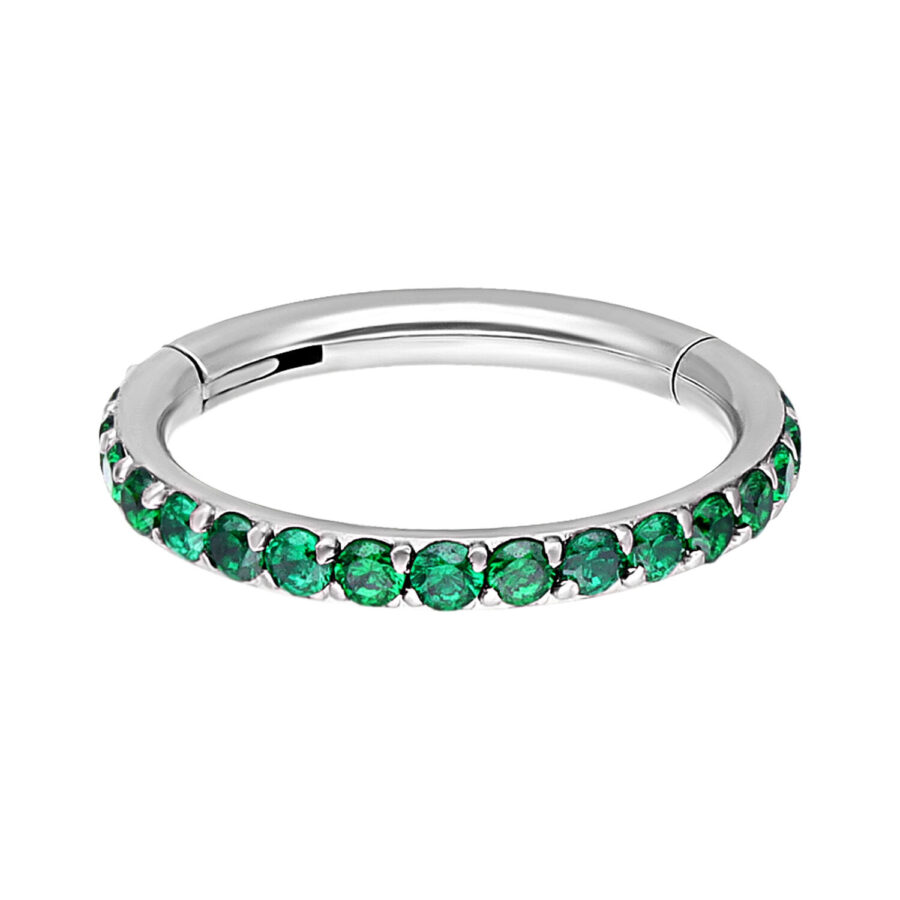 Anillo de piercing plateado con cristales esmeralda sobre fondo blanco