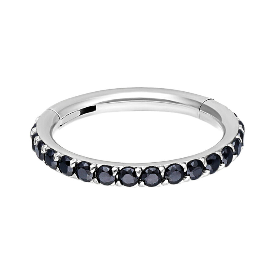 Anillo plateado con cristales negros sobre fondo blanco