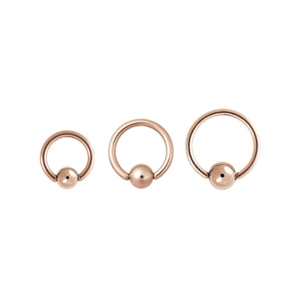 Tres anillos clip en de oro rosa de acero quirúrgico sobre fondo blanco