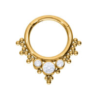 Anillo de piercing dorado con tres cristales claros sobre fondo blanco