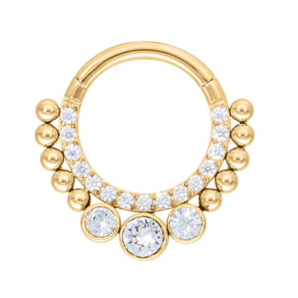 Clicker de septum dorado con cristales claros sobre fondo blanco