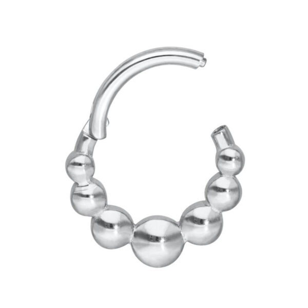 Clicker de septum plateado con diseño de bolas sobre fondo blanco