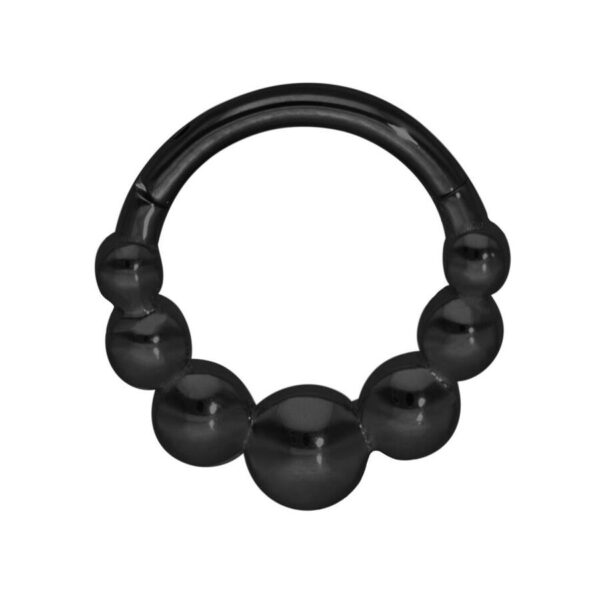 Anillo de piercing negro con diseño de bolas sobre fondo blanco