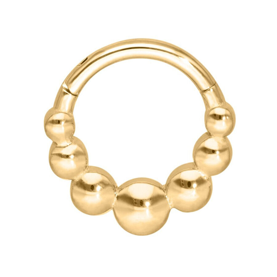 Aro de piercing dorado con diseño de bolas sobre fondo blanco