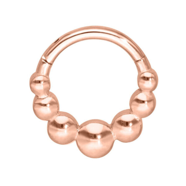 Anillo de piercing en oro rosa con bolas sobre fondo blanco