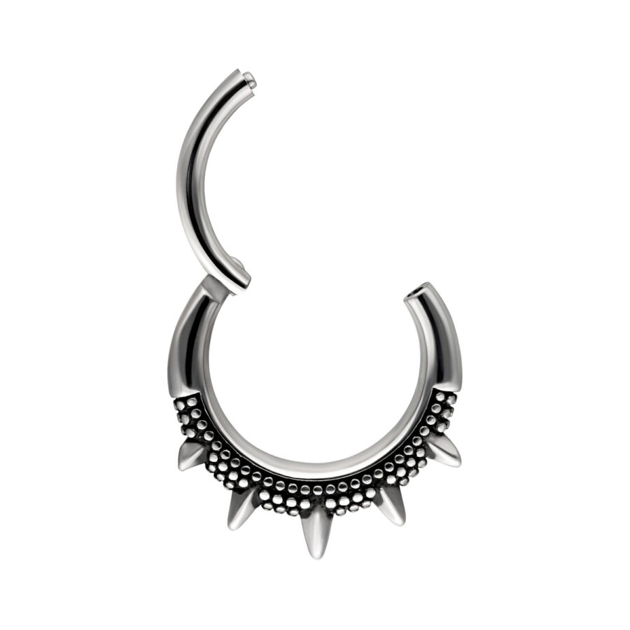 Anillo de piercing plateado con púas sobre fondo blanco