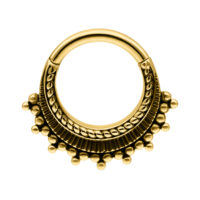 Anillo de piercing dorado con bolas decorativas sobre fondo blanco