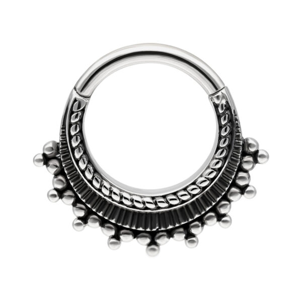 Aro de piercing plateado con adornos sobre fondo blanco