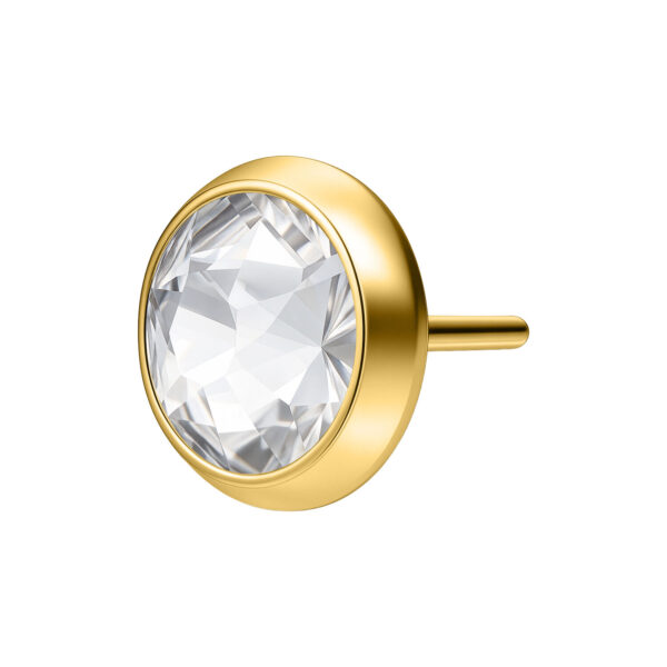 Ajuste de piercing dorado con piedra cristalina sobre fondo blanco