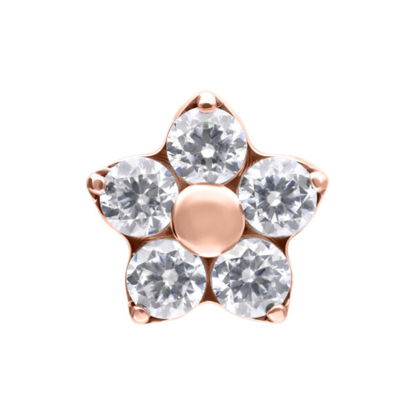 Adorno en forma de flor en rosado dorado con cinco cristales claros sobre fondo blanco