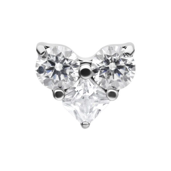 Triple accesorio de corazón de cristal de titanio con piedra clara sobre fondo blanco