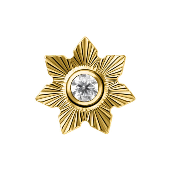 Aplique metálico dorado en forma de flor con cristal claro en el centro sobre fondo blanco