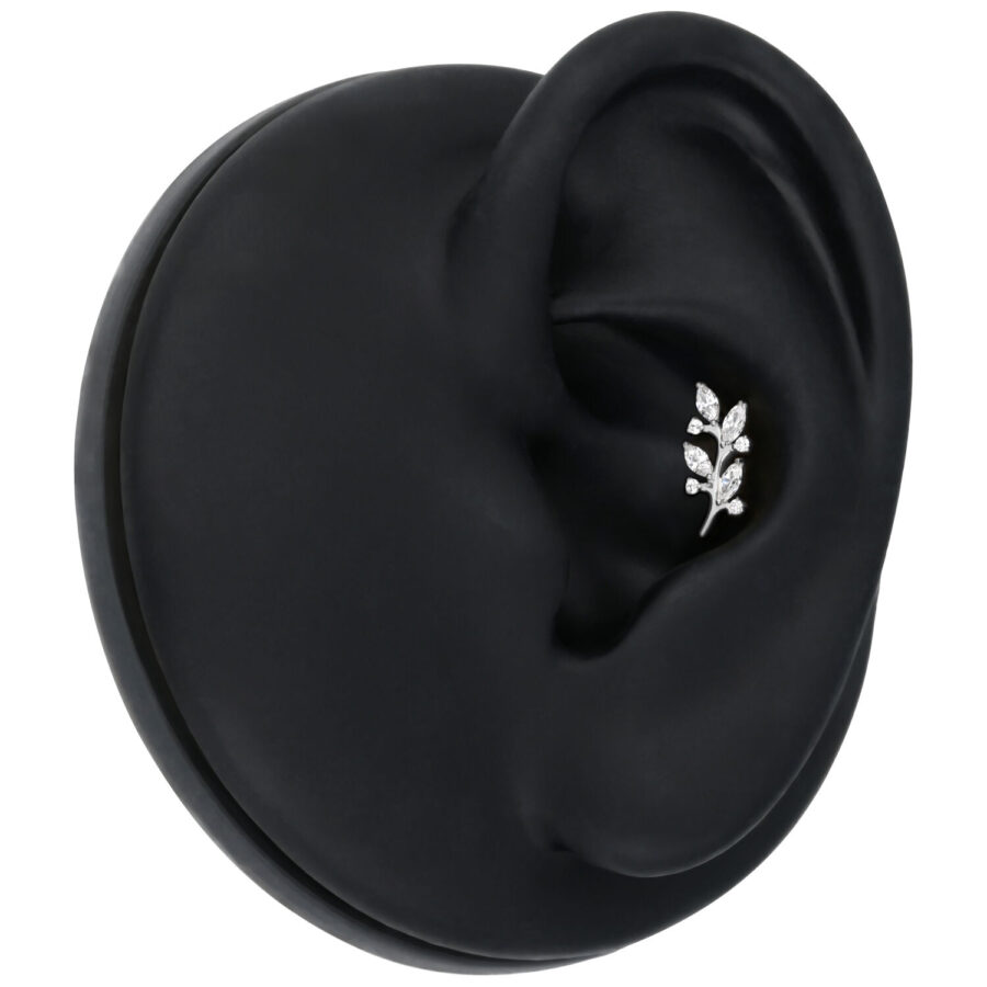 Accesorio de hojas de cristal plateado en oreja negra sobre fondo neutro