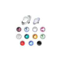 Accesorios de titanio plateados con cristales de colores sobre fondo blanco