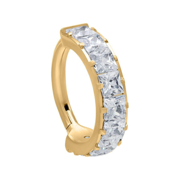 Anillo dorado con bisagra y cristales claros sobre fondo blanco